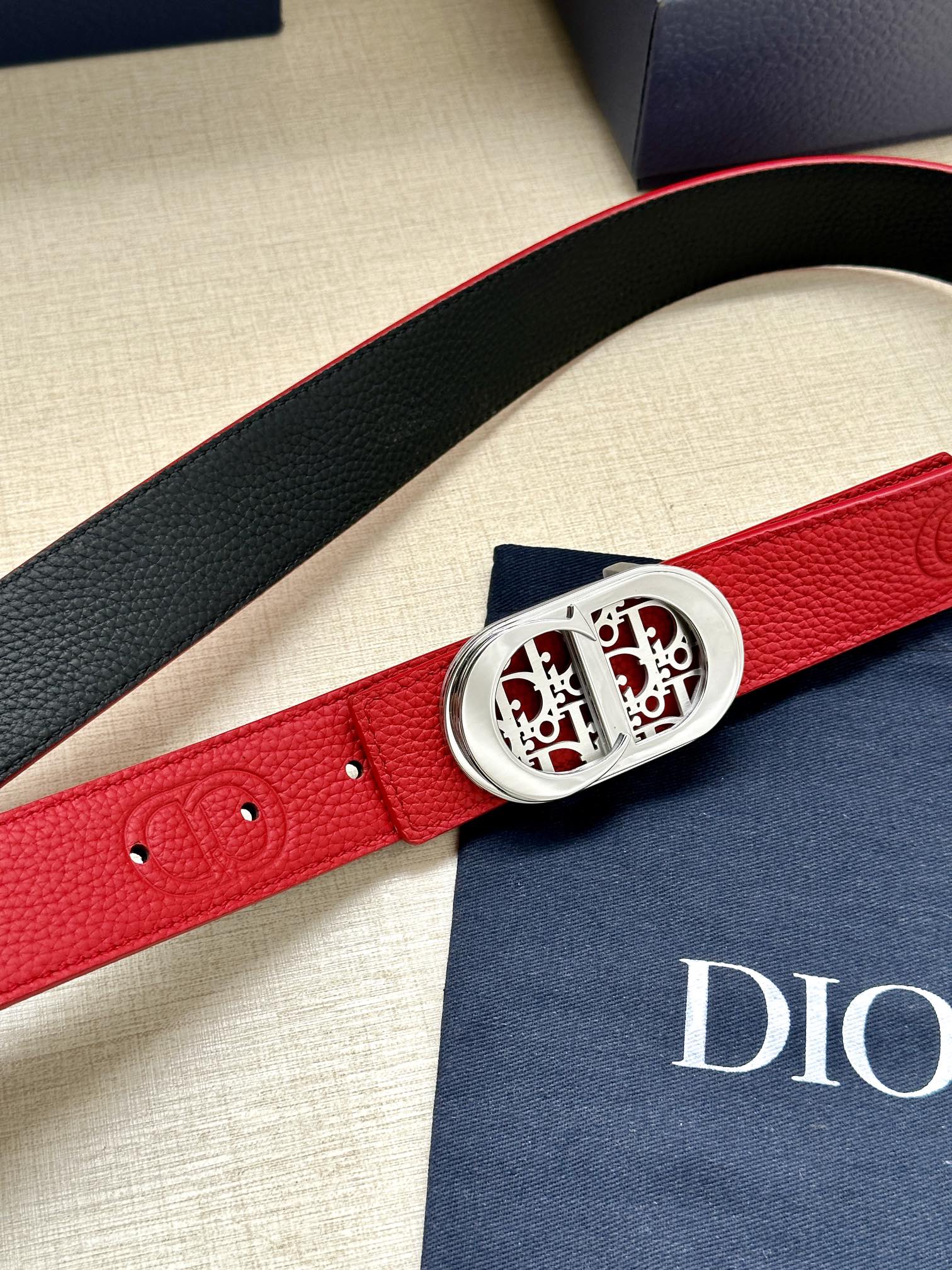 Red leather belt with silver-tone oval buckle and textured strap detail