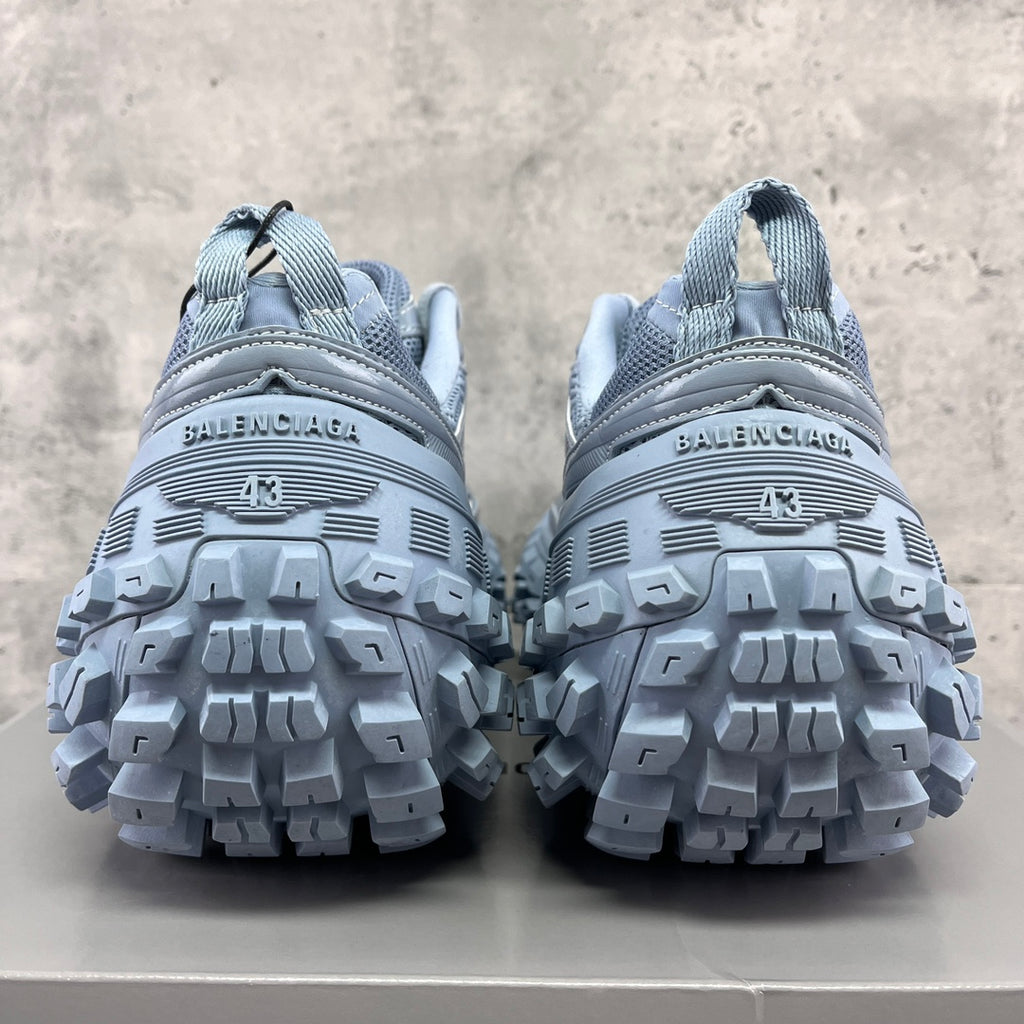 Light gray Balenciaga sneakers with rear logo strip and rugged tread sole
