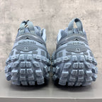 Light gray Balenciaga sneakers with rear logo strip and rugged tread sole