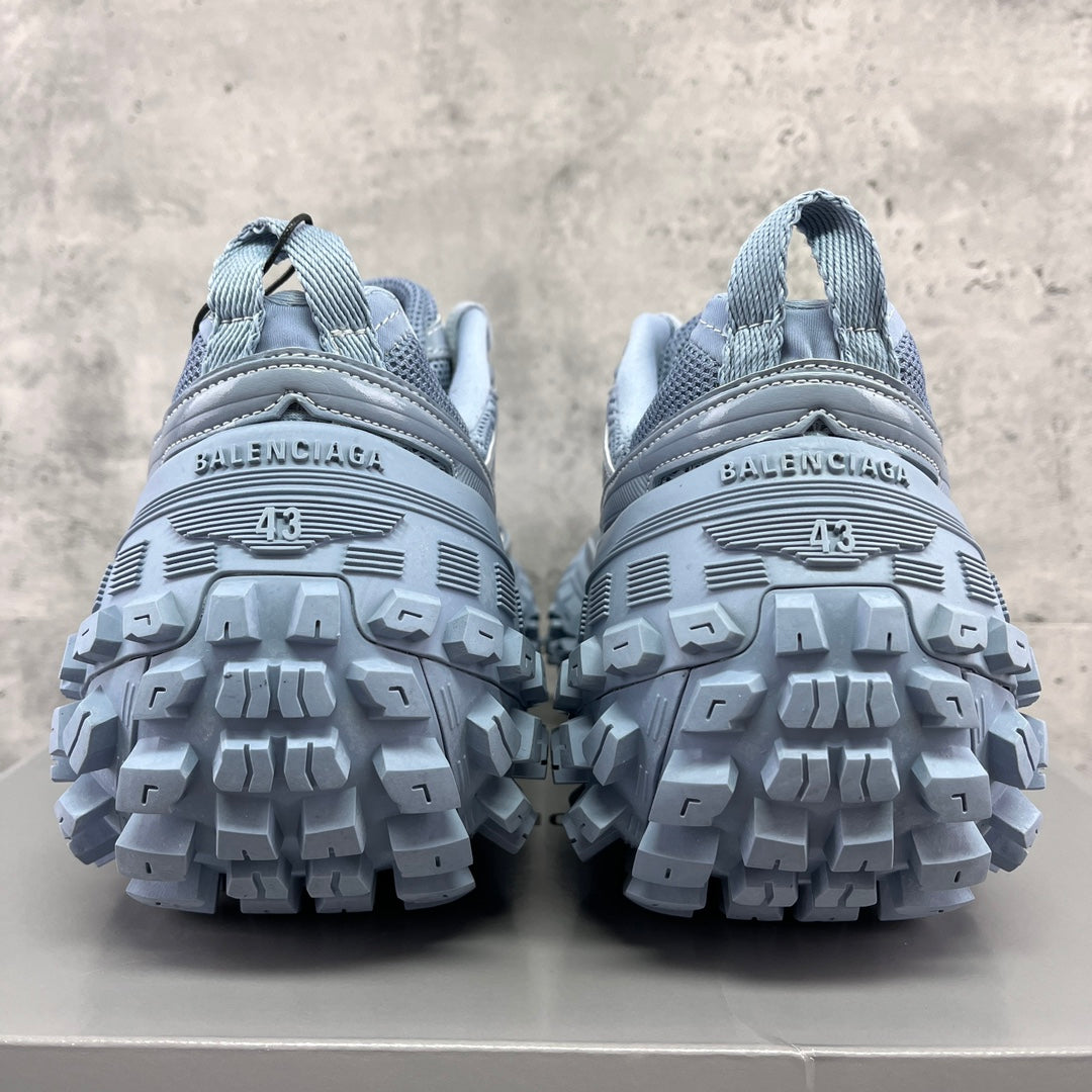 Light gray Balenciaga sneakers with rear logo strip and rugged tread sole