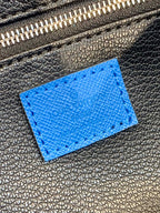 Louis Vuitton blue monogram leather patch detail on dark zipper