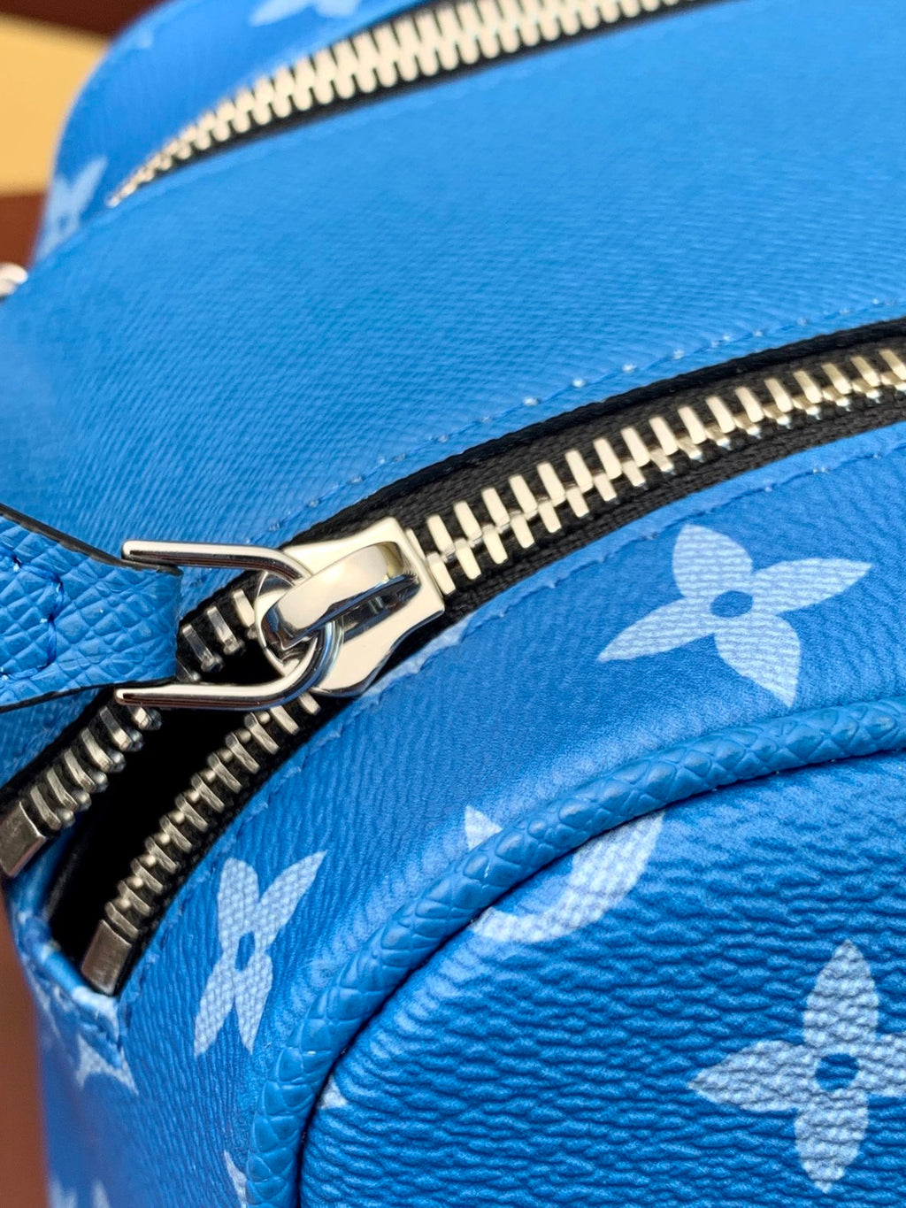 Louis Vuitton blue monogram bag corner with metal zipper pull detail