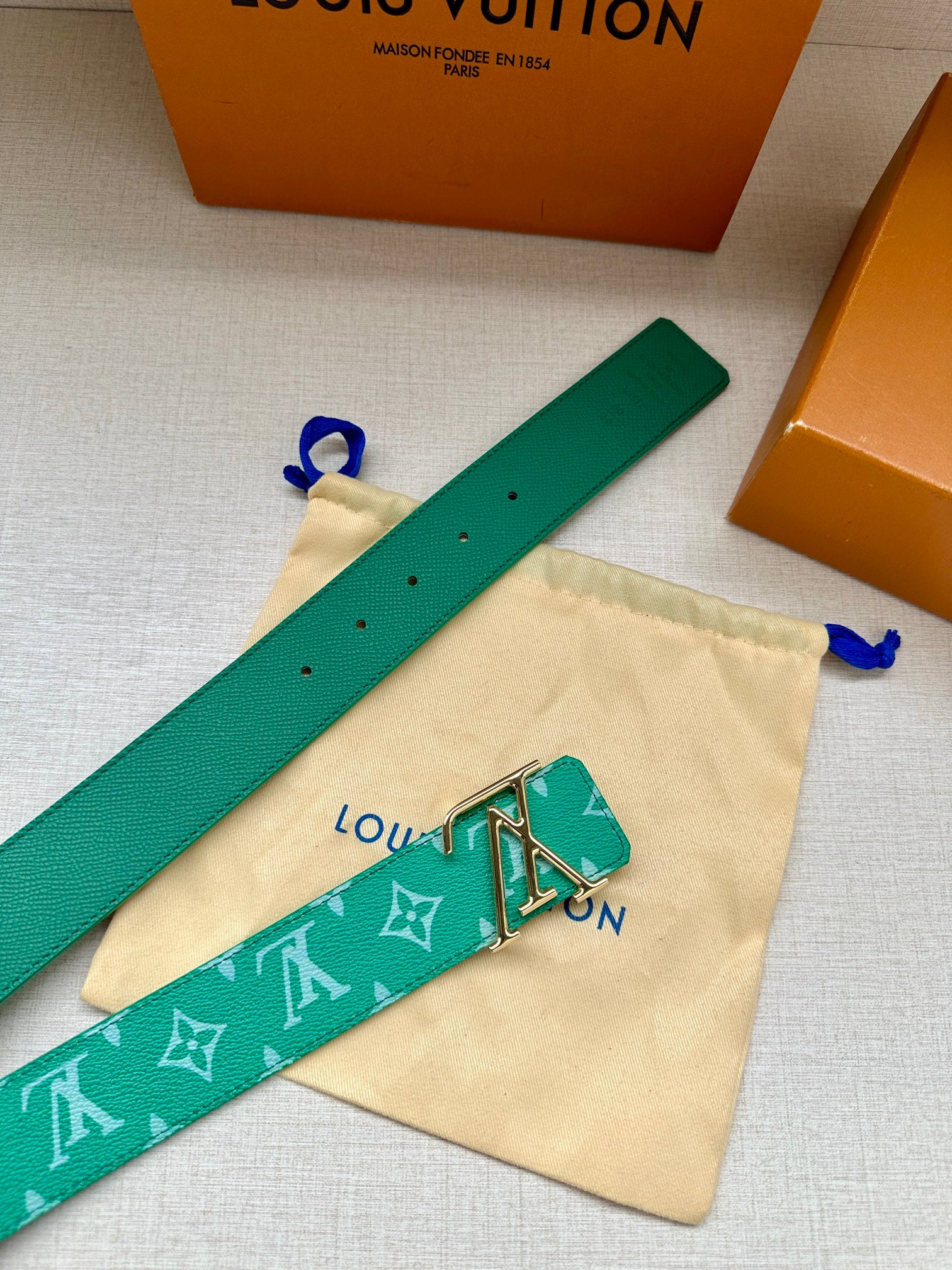 Louis Vuitton green monogram belt laid flat with gold-tone LV buckle