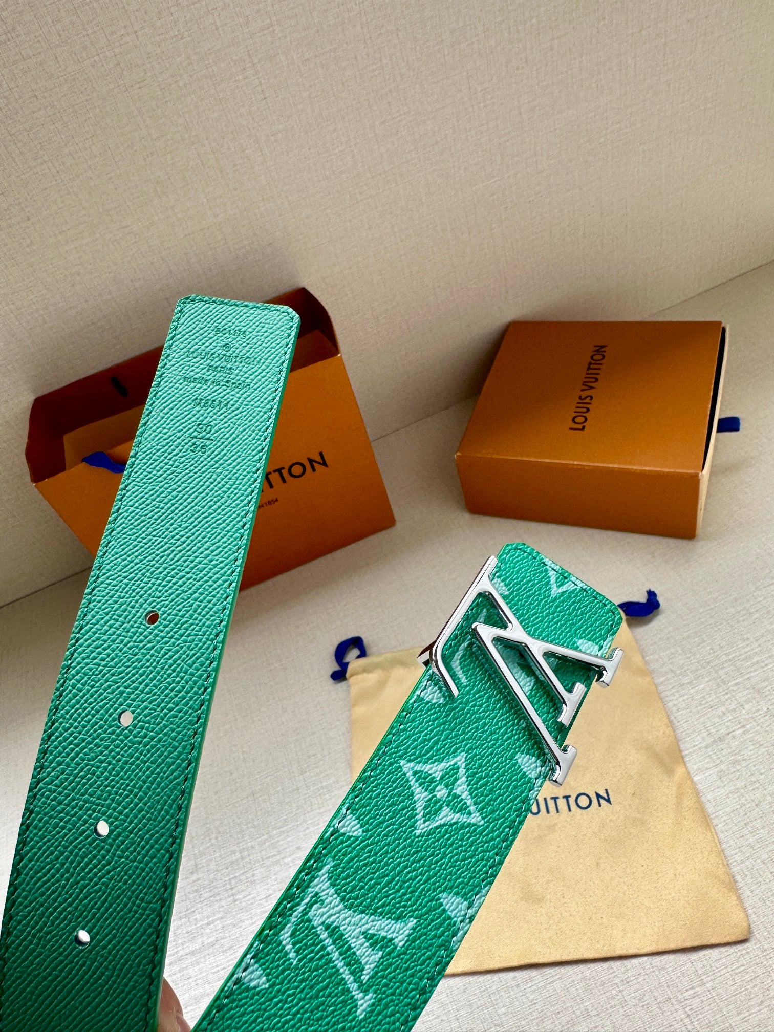 Louis Vuitton green monogram belt with gold-tone LV buckle, shown with pouch