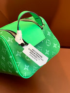 Louis Vuitton monogram bag with hanging product tag, bright green leather and top handle