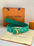 Green logo belt with gold buckle on cream pouch with embossed design