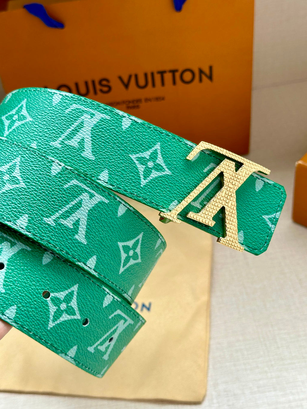 Green logo belt with gold-tone LV buckle and patterned strap end