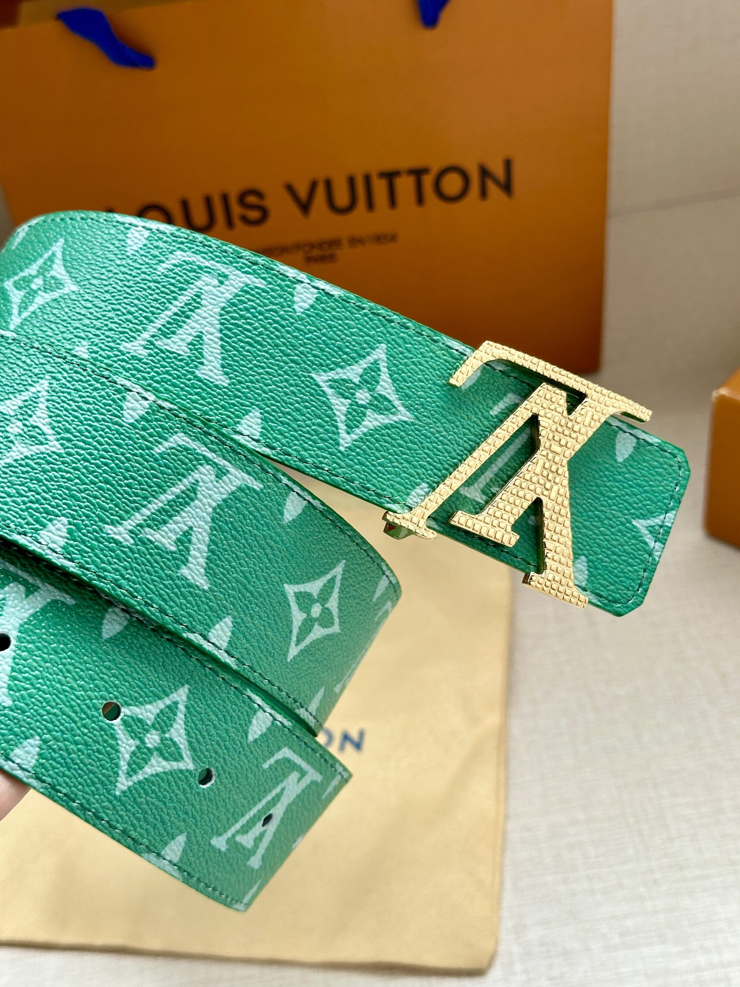 Green logo belt with gold-tone LV buckle and patterned strap end