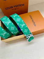 Green logo belt with gold buckle, shown folded with matching strap loops