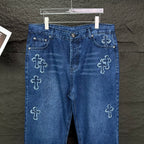 Blue denim pants front view with cross embroidery on legs and front pockets.