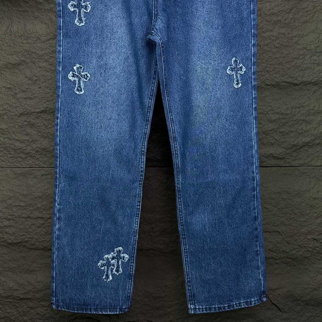 Blue denim pants with cross embroidery on both legs and straight cropped hem.