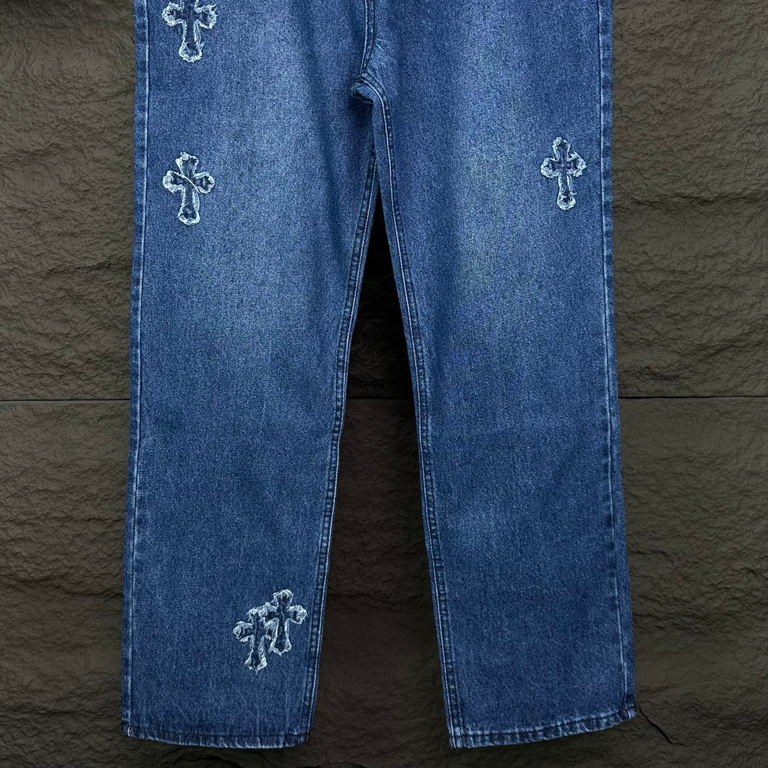 Blue denim pants with cross embroidery on both legs and straight cropped hem.