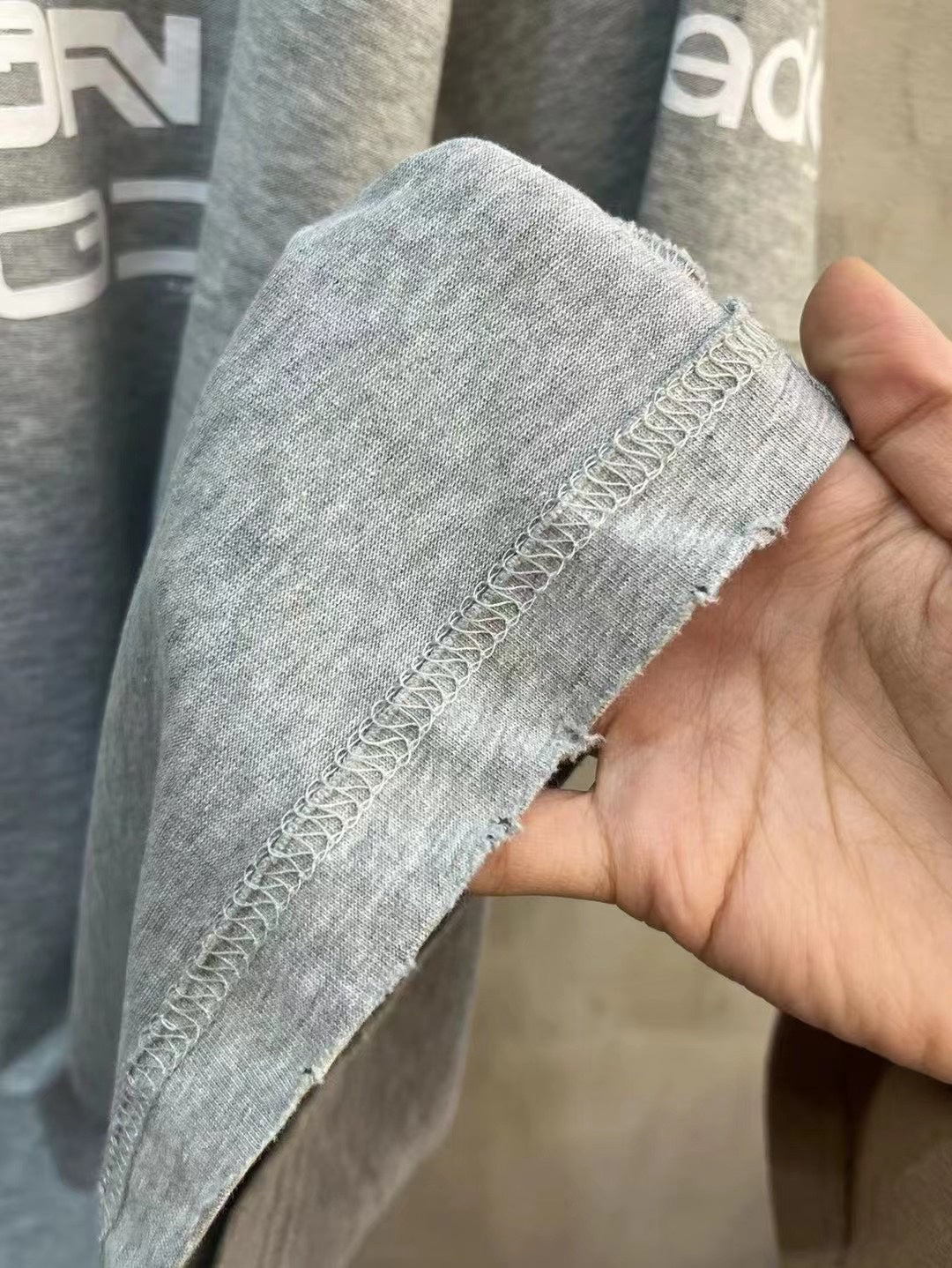 Light gray T-shirt sleeve hem with visible stitching