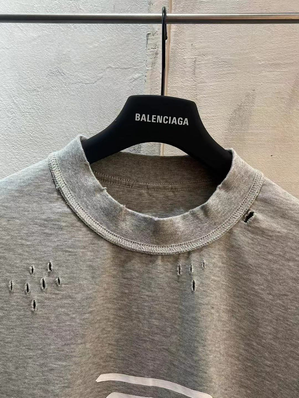 Light gray T-shirt with crew neckline and small stud accents near the chest