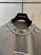Light gray T-shirt with crew neckline and small stud accents near the chest