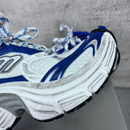 Close-up of white and blue chunky sneakers with lace-up front and textured sole