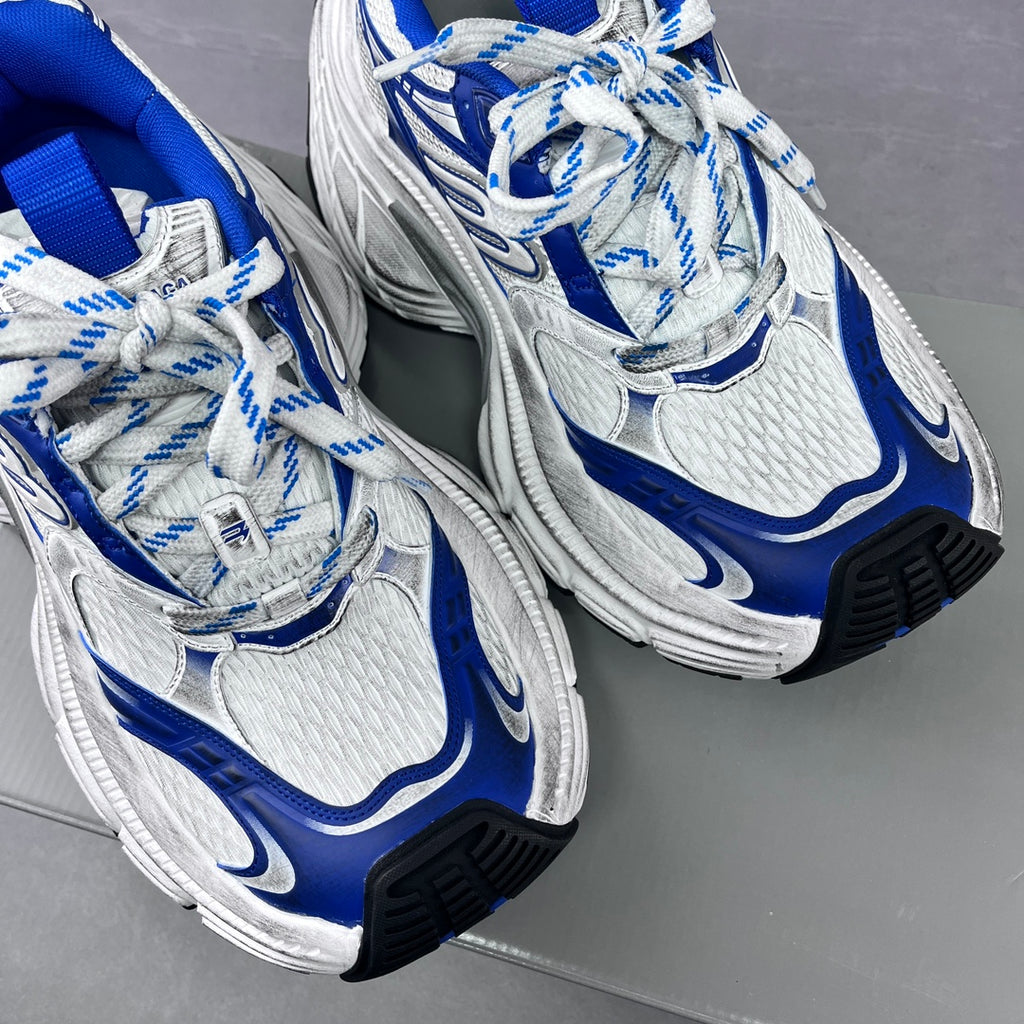 Pair of white and blue lace-up sneakers with mesh texture and chunky sole