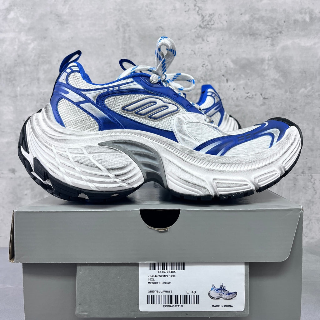 Chunky lace-up sneakers with blue overlays, white uppers, and thick gray sole