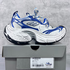 Chunky lace-up sneakers with blue overlays, white uppers, and thick gray sole