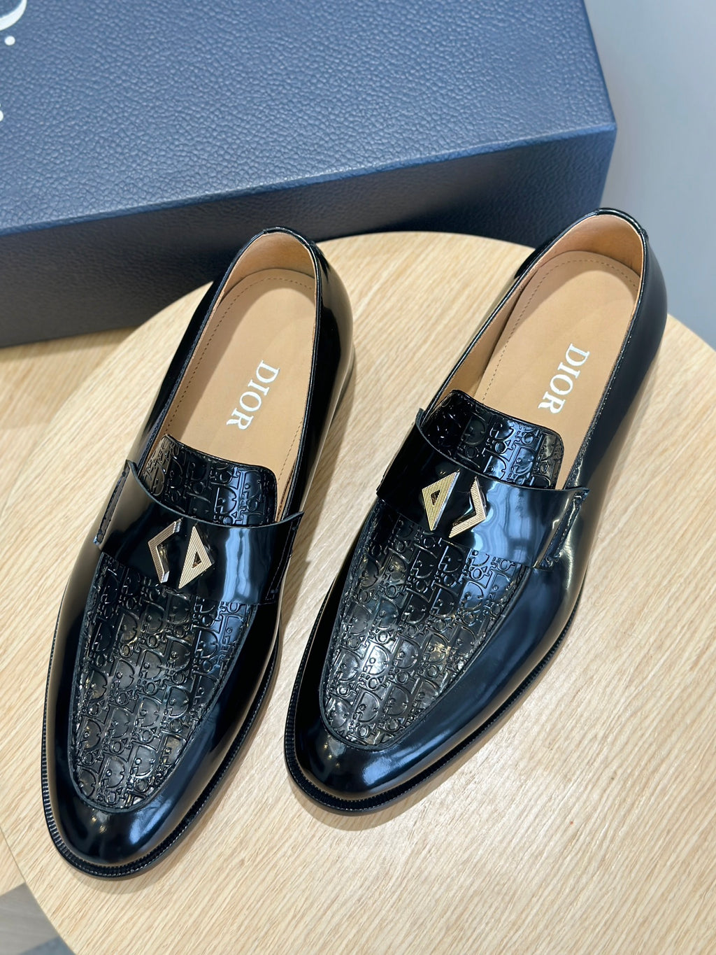 Dior unisex patent leather loafers, black with gold emblem, front view