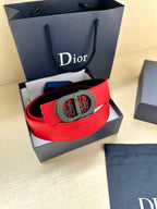 Red Dior belt in leather with gray oval patterned buckle, shown in a gift box.