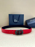 Dior belt in red leather with dark oval logo buckle and punched holes.