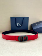 Dior belt in red leather with dark oval logo buckle and punched holes.