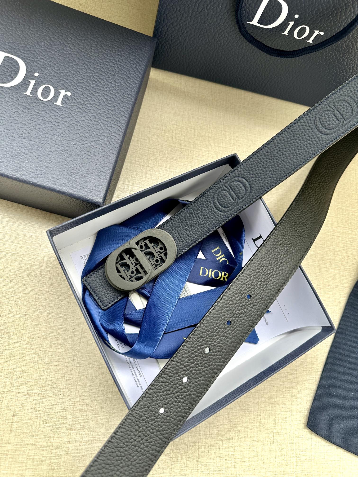Dior belt with blue leather strap and oval logo buckle, partially boxed