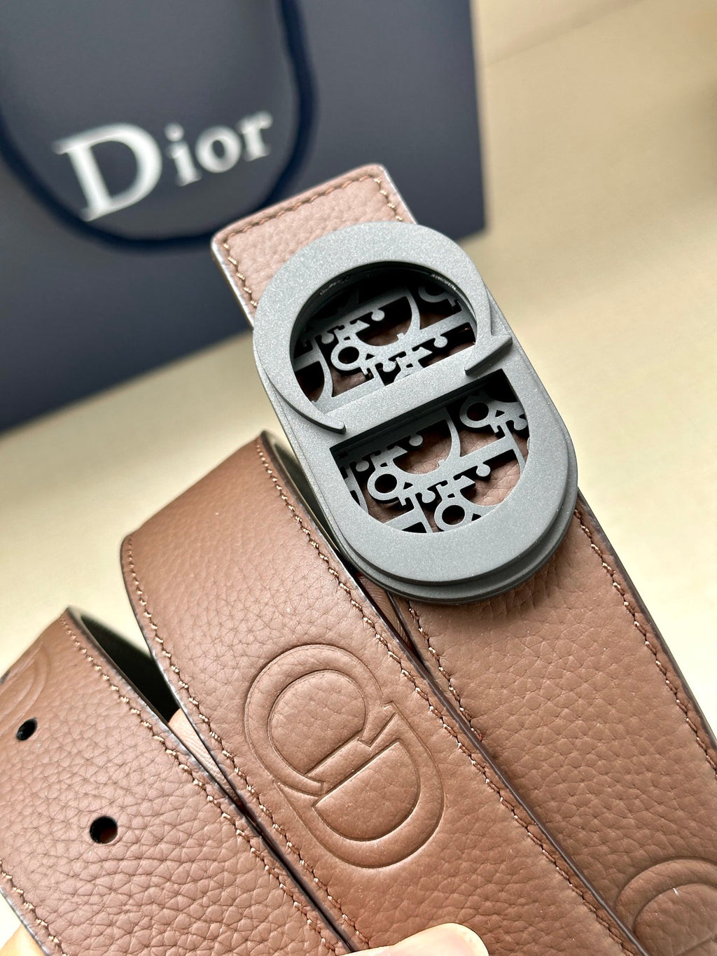 Brown leather belt buckle with engraved Dior monogram and stitched strap