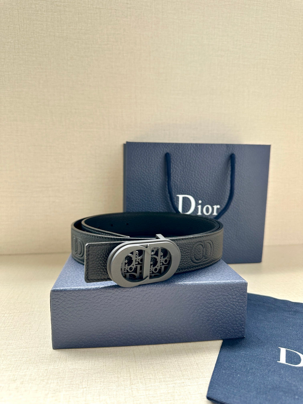 Dior belt dark leather with embossed logo belt holes and round patterned buckle