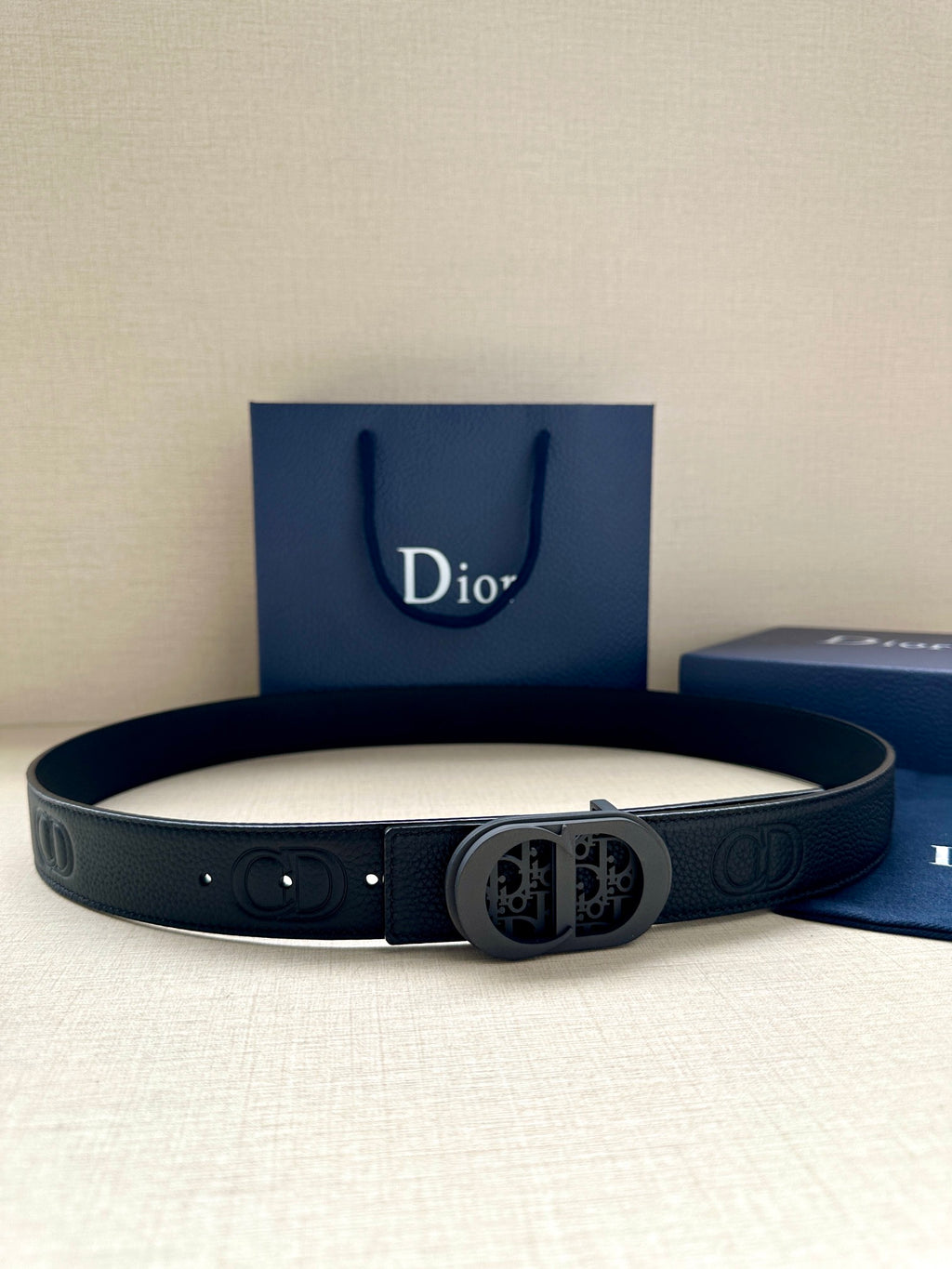 Dior belt in dark leather with embossed logo and round patterned buckle
