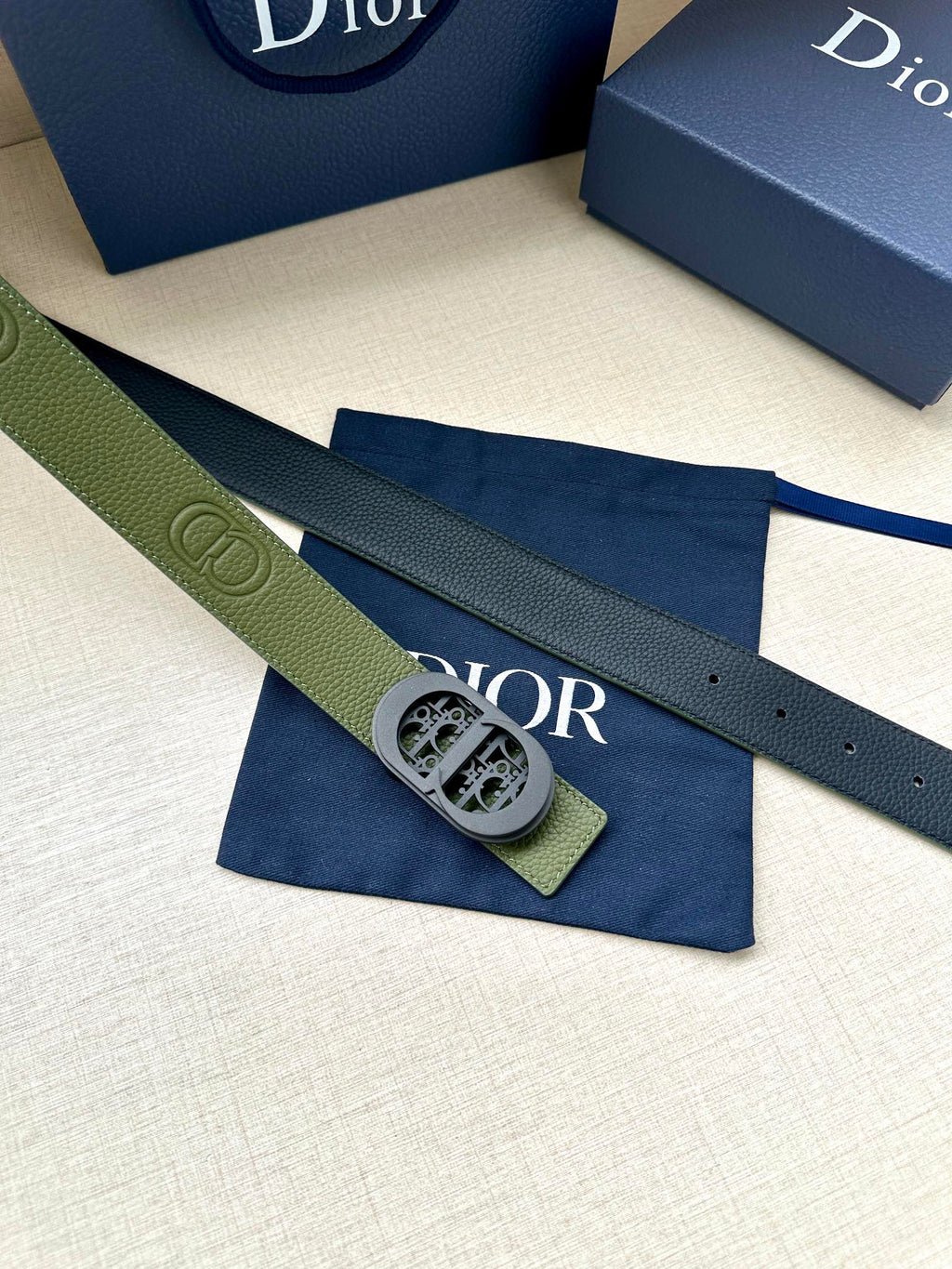 Green leather Dior belt with oval logo buckle and stitched perforation holes