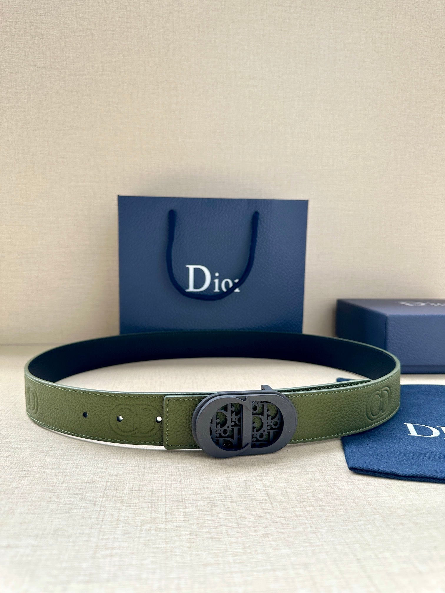 Green leather Dior belt with oval logo buckle and perforated holes