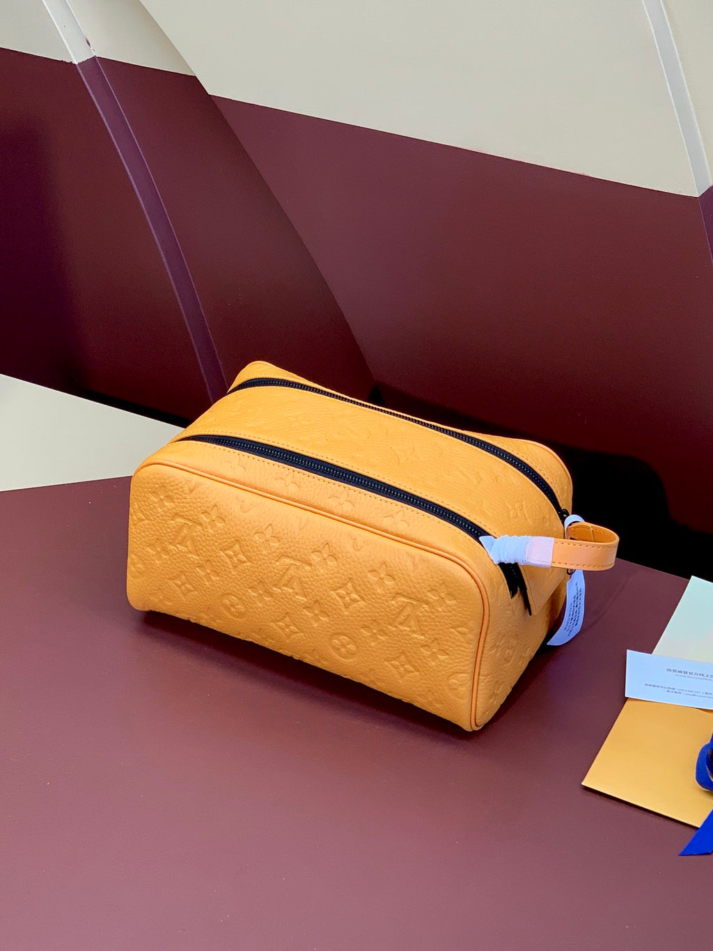 Mustard-yellow monogram crossbody bag with navy zip and strap
