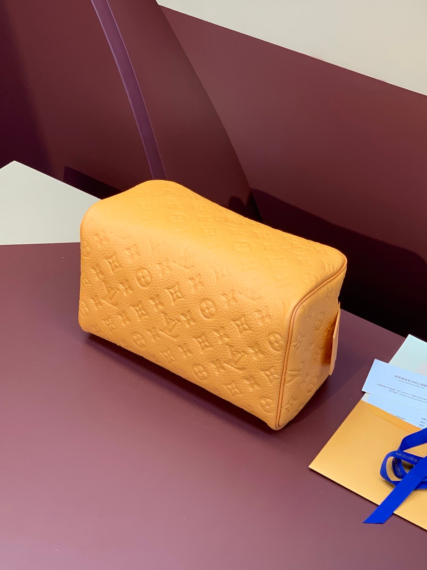 Mustard-yellow monogram handbag with rounded shape and top zipper