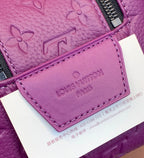 Purple embossed bag panel with stitched leather card tag and zipper edge