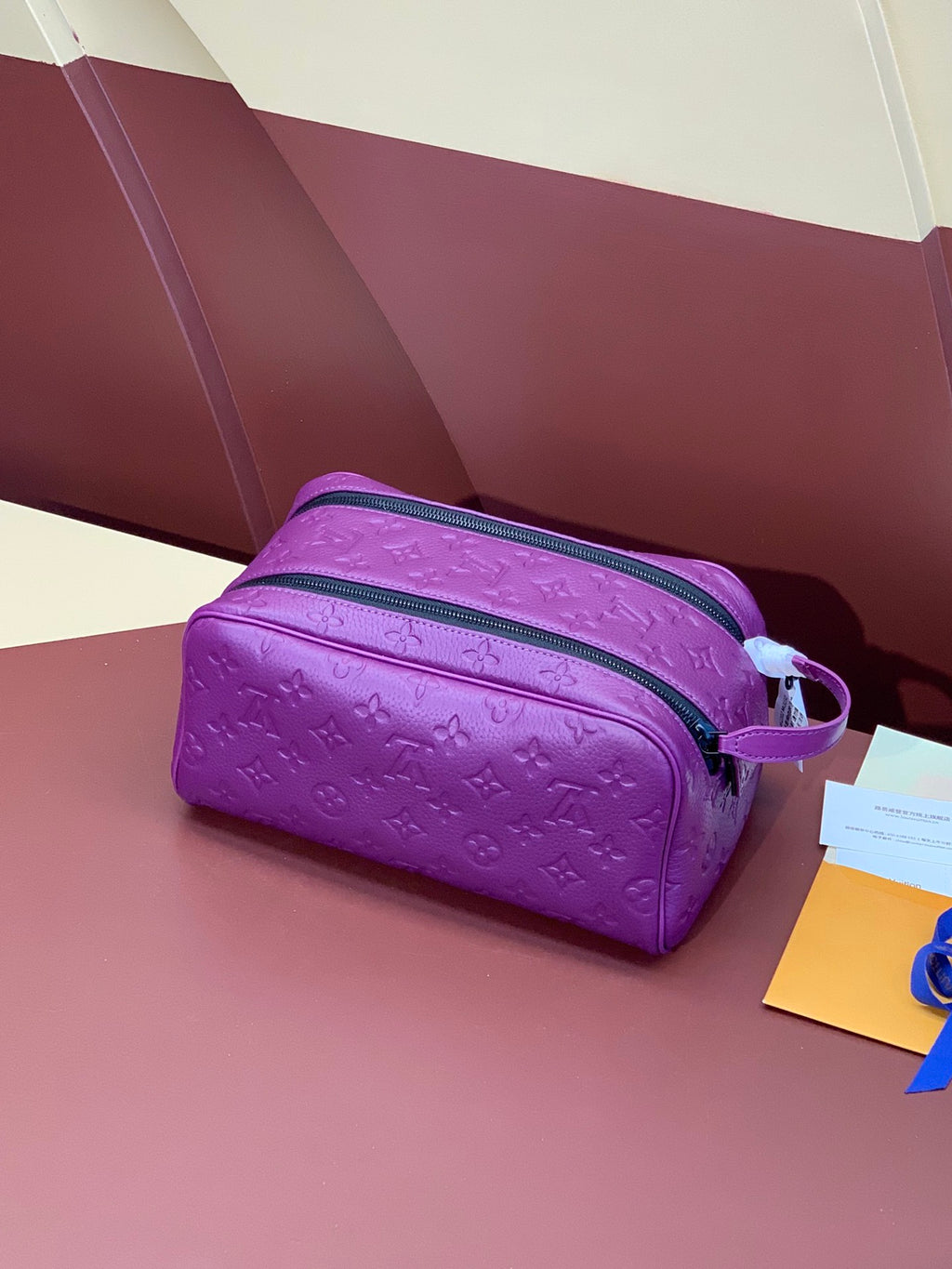 Louis Vuitton purple embossed crossbody bag with zip closure and shoulder strap