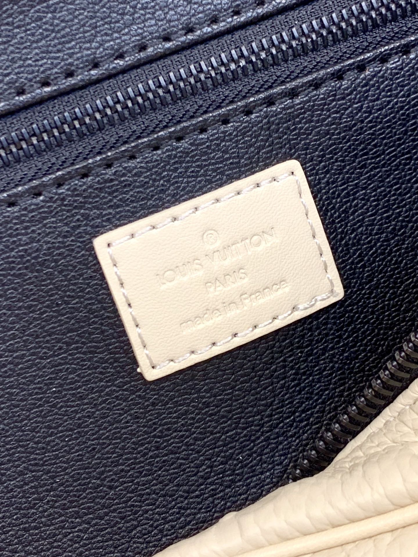 Louis Vuitton label patch on white leather pouch with dark blue zipper edge