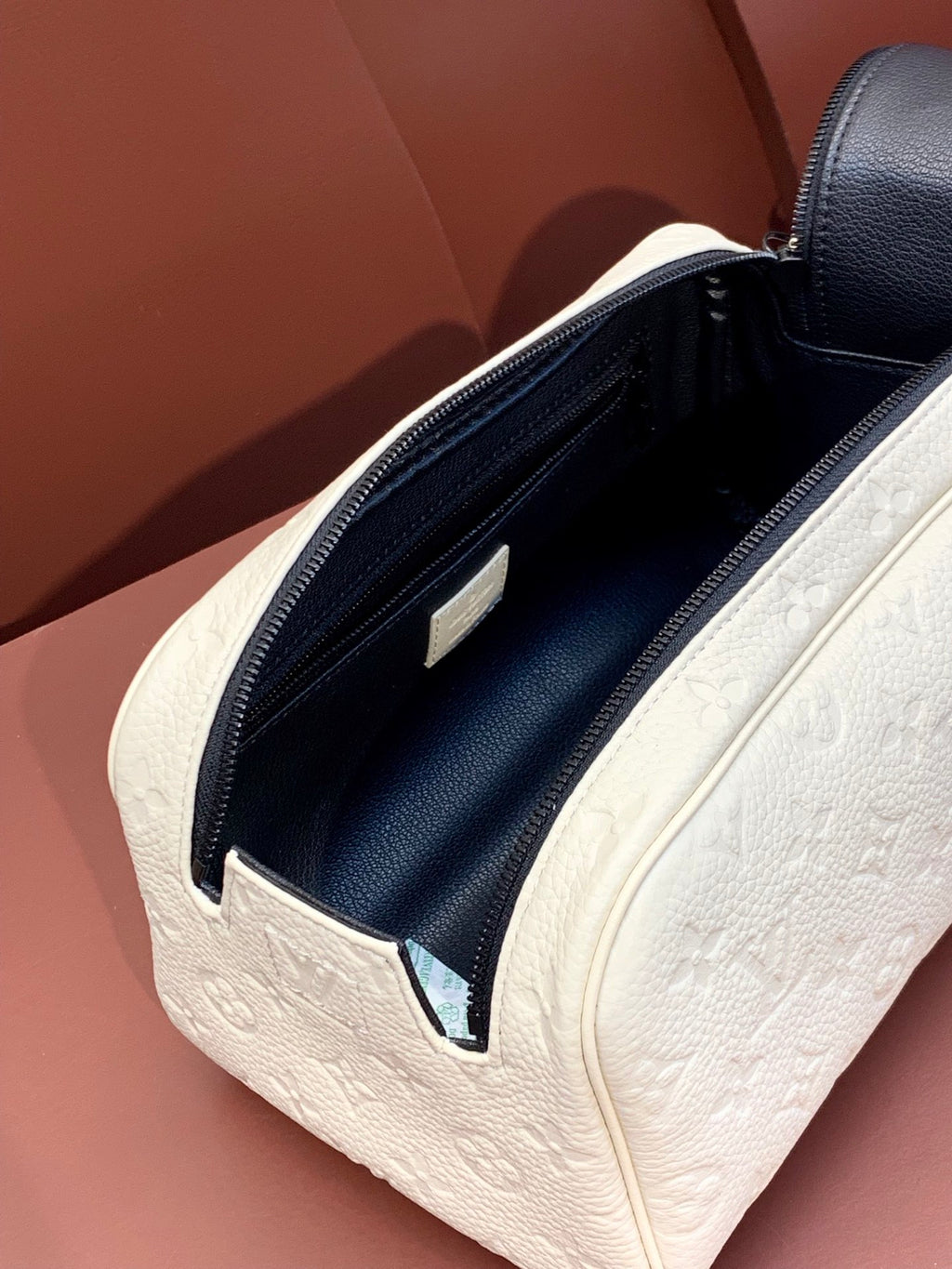 Louis Vuitton pouch bag interior view with navy lining and white monogram exterior