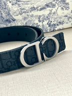 Dior belt close-up: dark navy strap and silver-tone oval CD buckle.