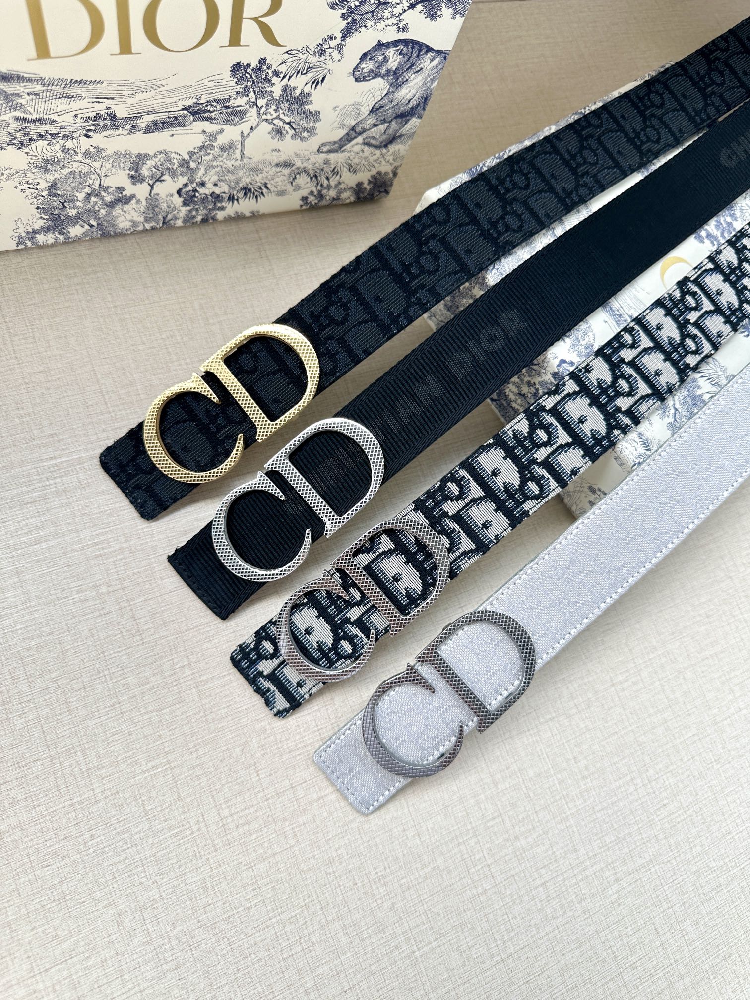 Dior belt set: dark navy and gray straps with silver-tone CD buckles.