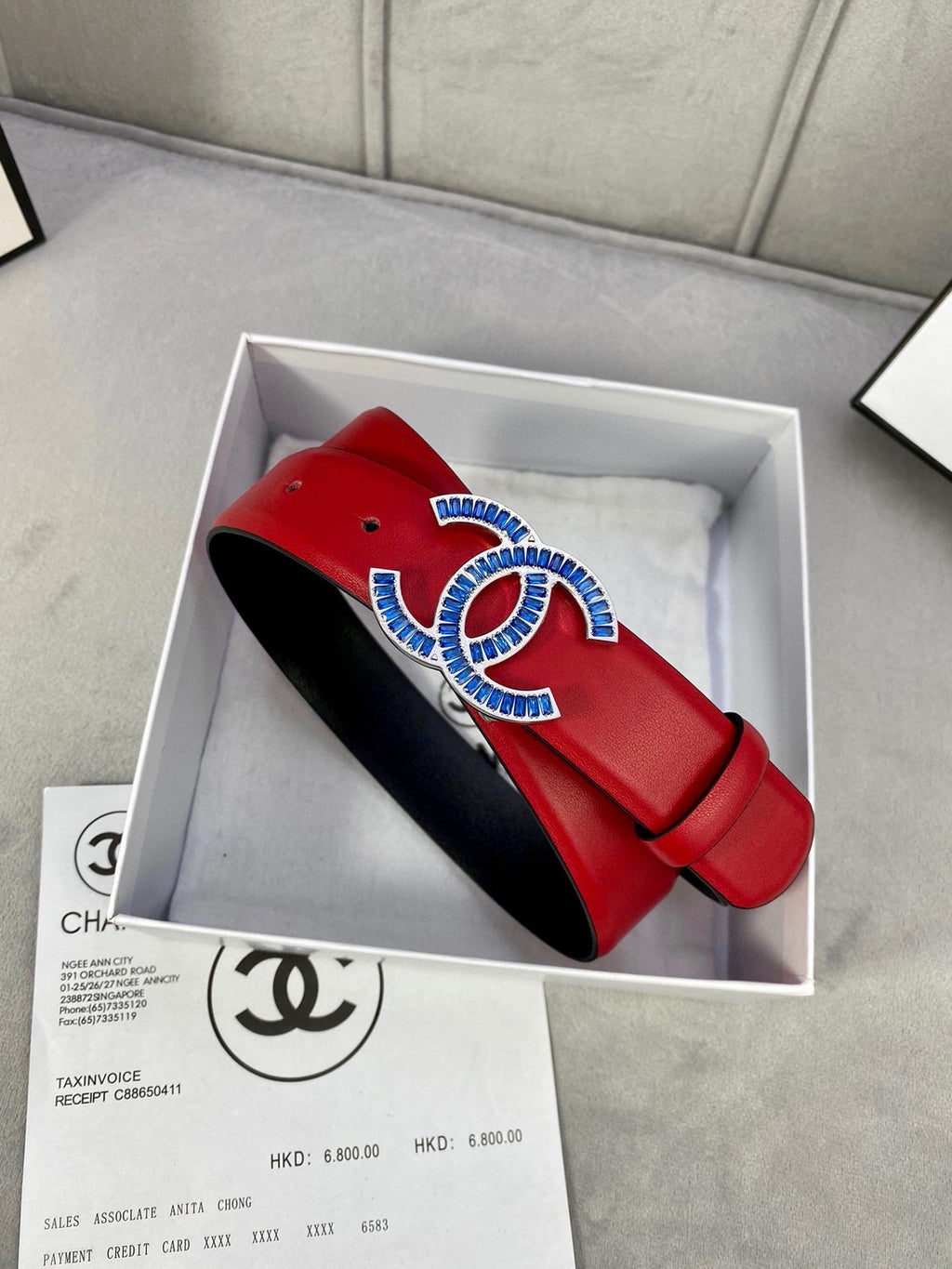 Chanel belt red strap with black underside, displayed in box with papers