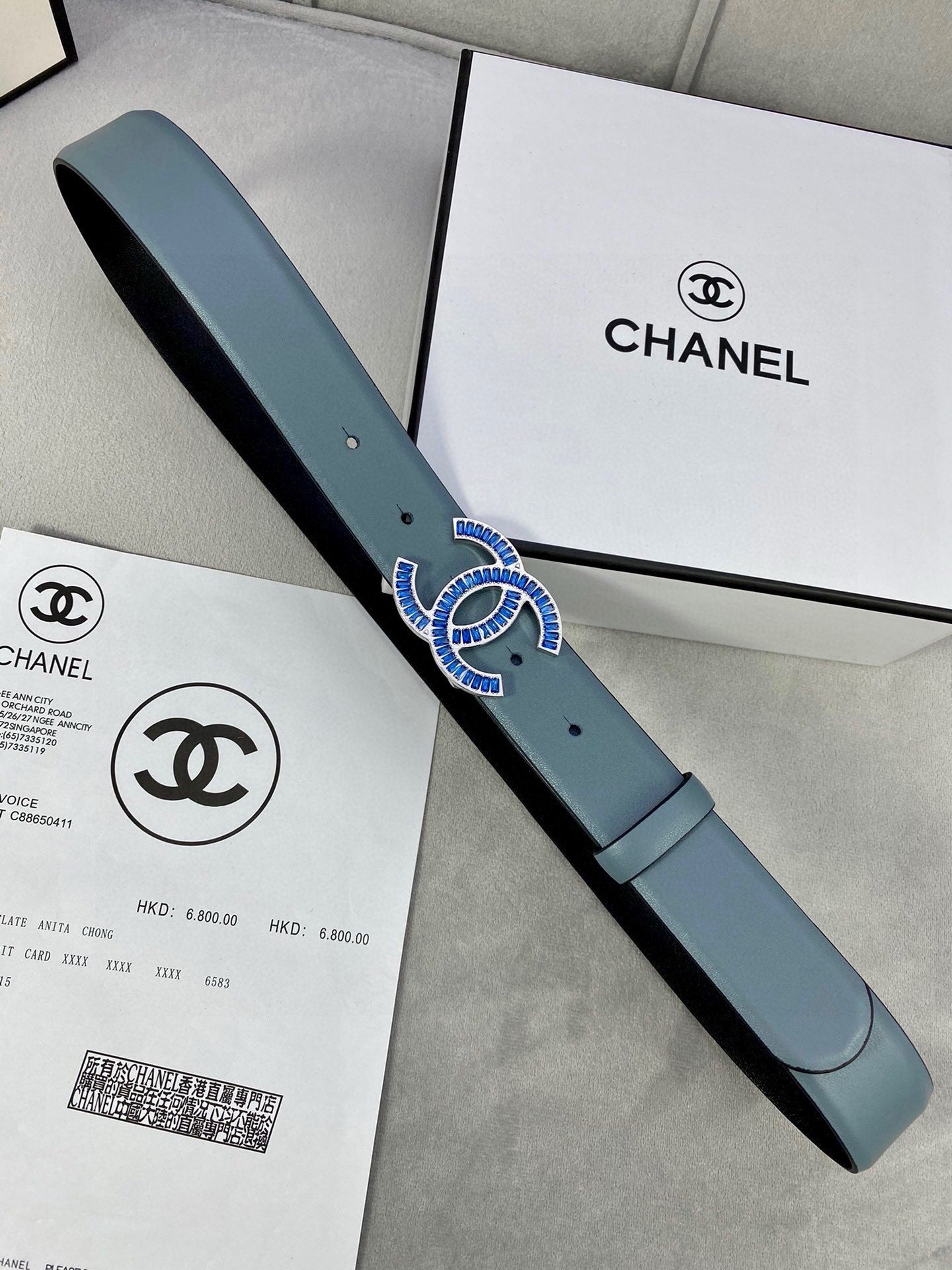 Chanel belt in light blue with CC buckle, paired with product papers