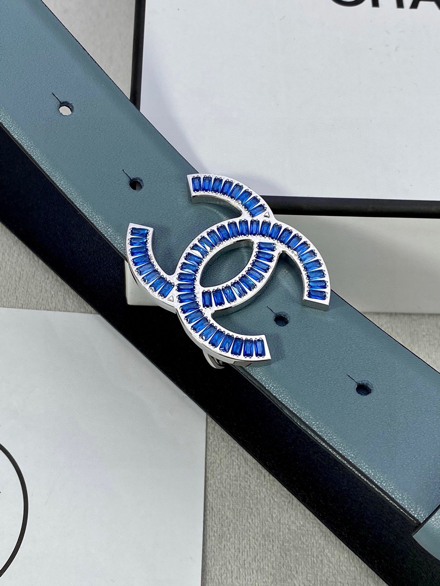 Chanel belt buckle close-up on light blue leather strap