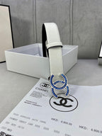 White leather belt with blue CC buckle and adjustable strap holes in box.