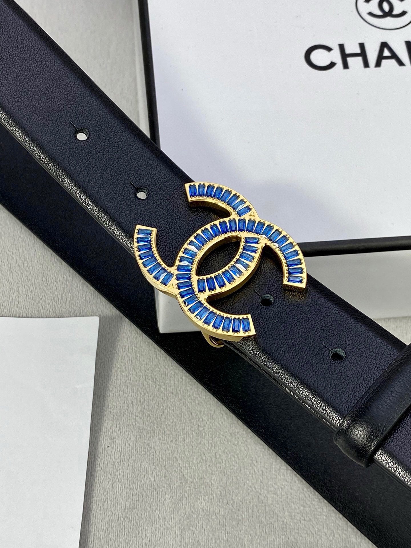 Black Chanel belt with blue jeweled CC buckle, detailed close-up