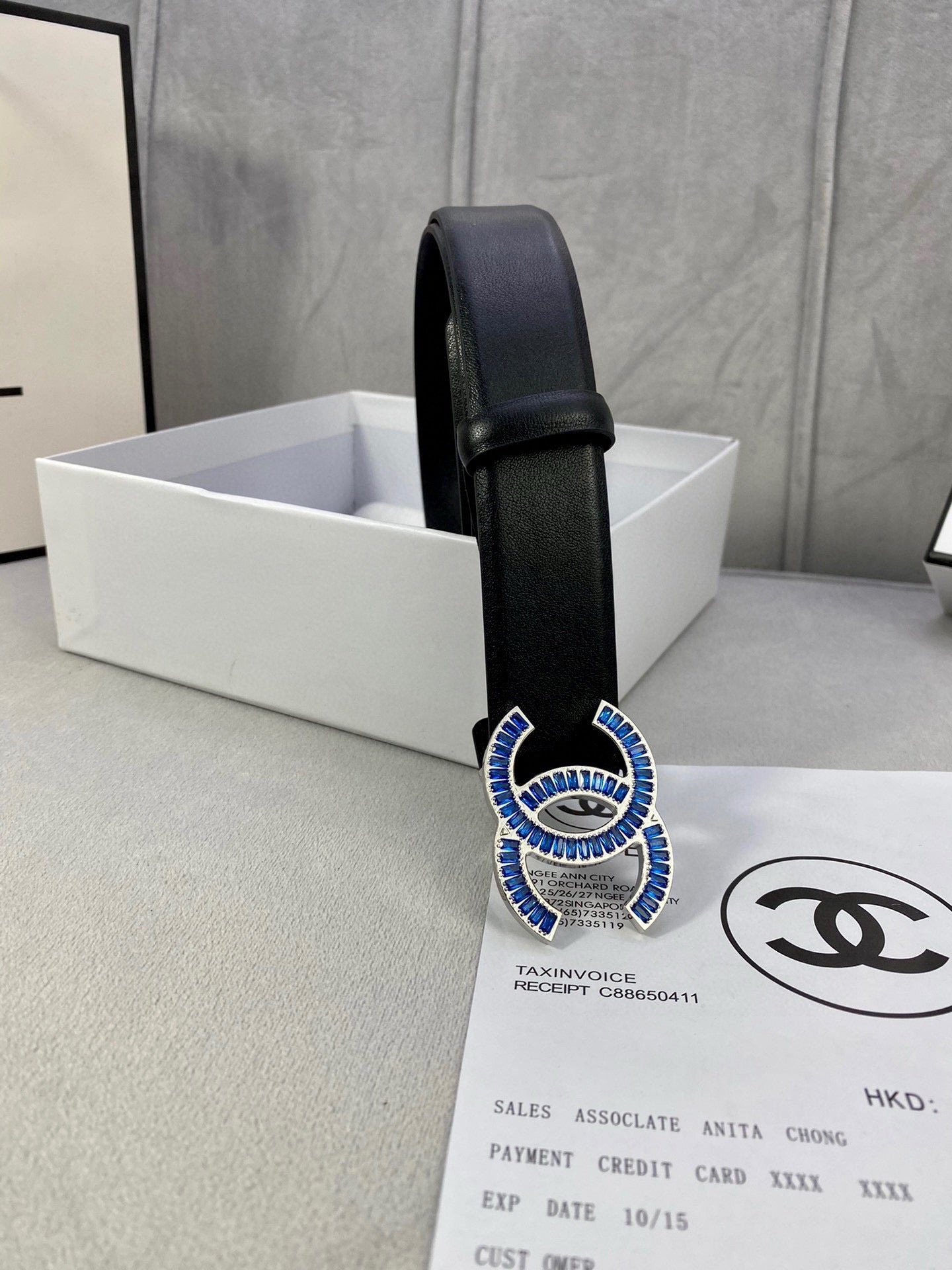 Black Chanel belt with blue jeweled CC buckle, angled view