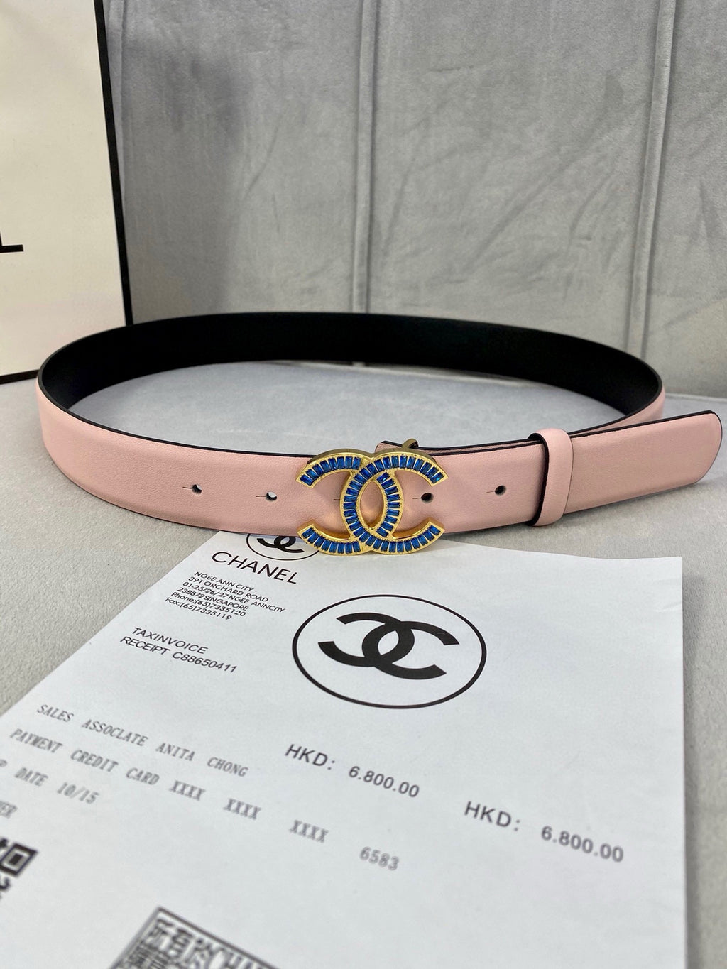 Chanel belt in pink leather with blue and gold CC-style buckle, black underside.