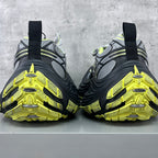 Back view of chunky sneakers with neon yellow tread and black heel straps