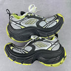 Front view of chunky lace-up sneakers in gray and black with neon yellow highlights
